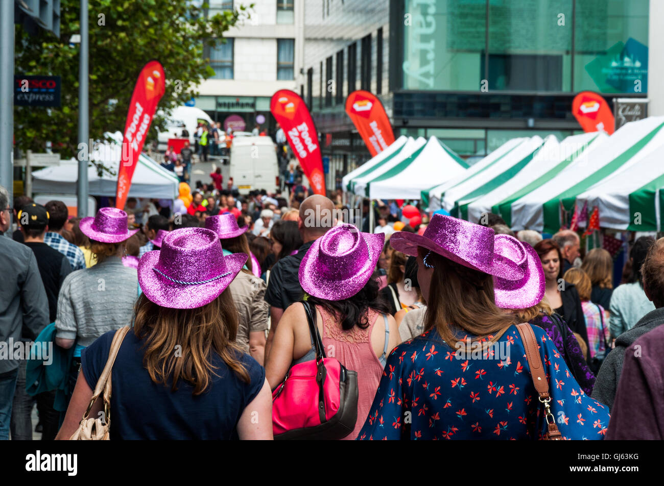 Foule de personnes et groupe de femmes portant des chapeaux roses à Jubilee Street pendant le Brighton Festival à Brighton, East Essex, Royaume-Uni à partir de 2012 Banque D'Images