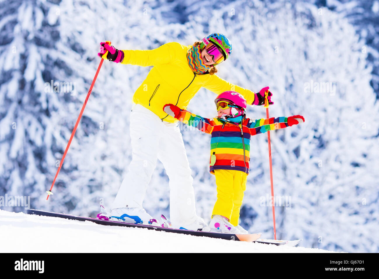 La mère et le petit enfant du ski dans les montagnes des Alpes. Maman active et tout-petit enfant avec casque de sécurité, lunettes et des poteaux. Banque D'Images