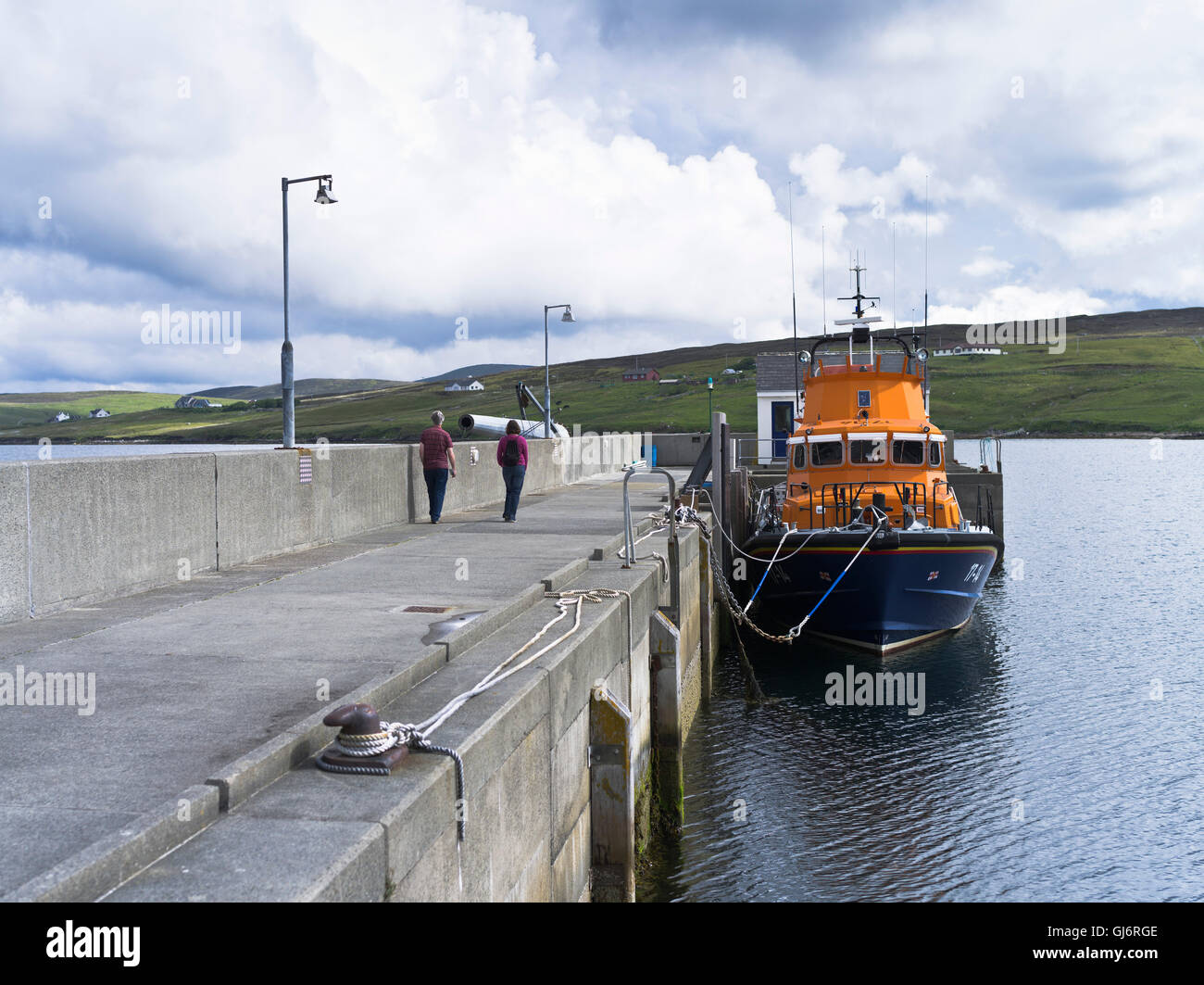 dh Harbour AITH SHETLAND couple de touristes à pied jetée pour regarder le canot de sauvetage 17-14 personnes rnli bateau de vie Banque D'Images