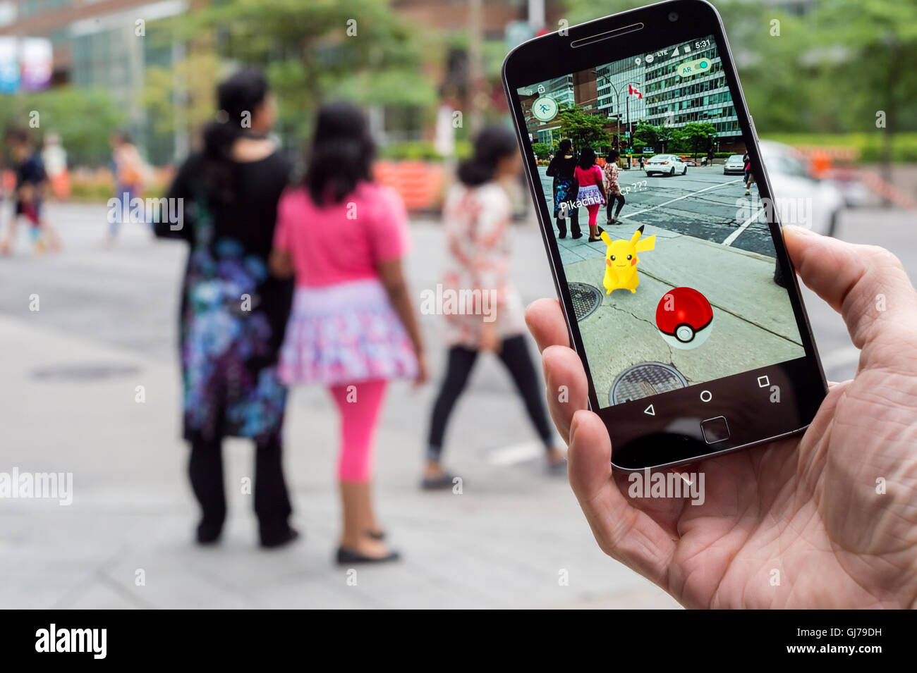 Montréal, CA - le 12 août 2016 : Libre d'un homme jouant de Pokemon rendez sur un téléphone intelligent. Banque D'Images
