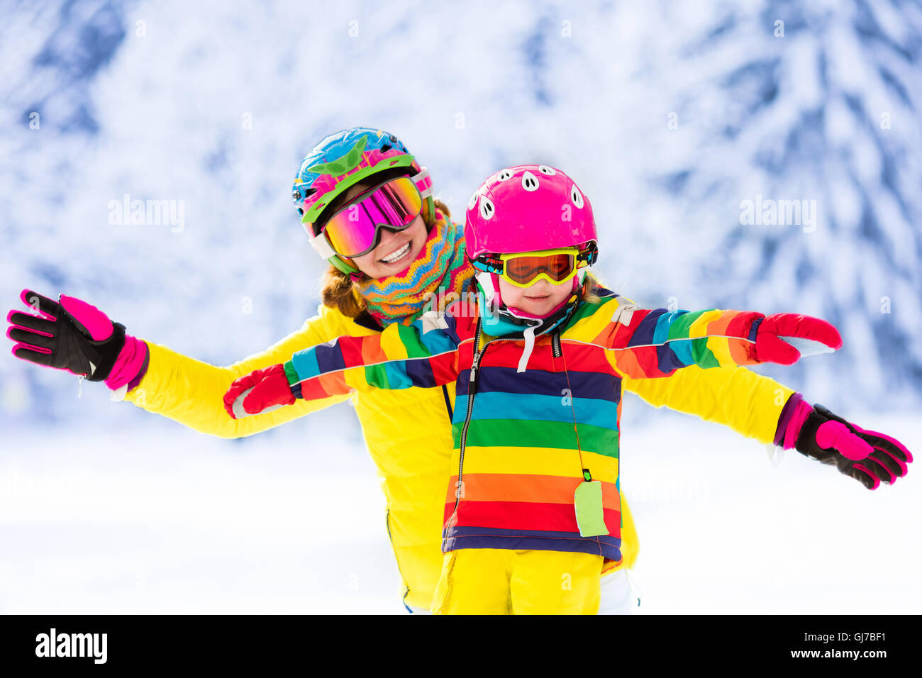 La mère et le petit enfant du ski dans les montagnes des Alpes. Maman active et tout-petit enfant avec casque de sécurité, lunettes et des poteaux. Banque D'Images