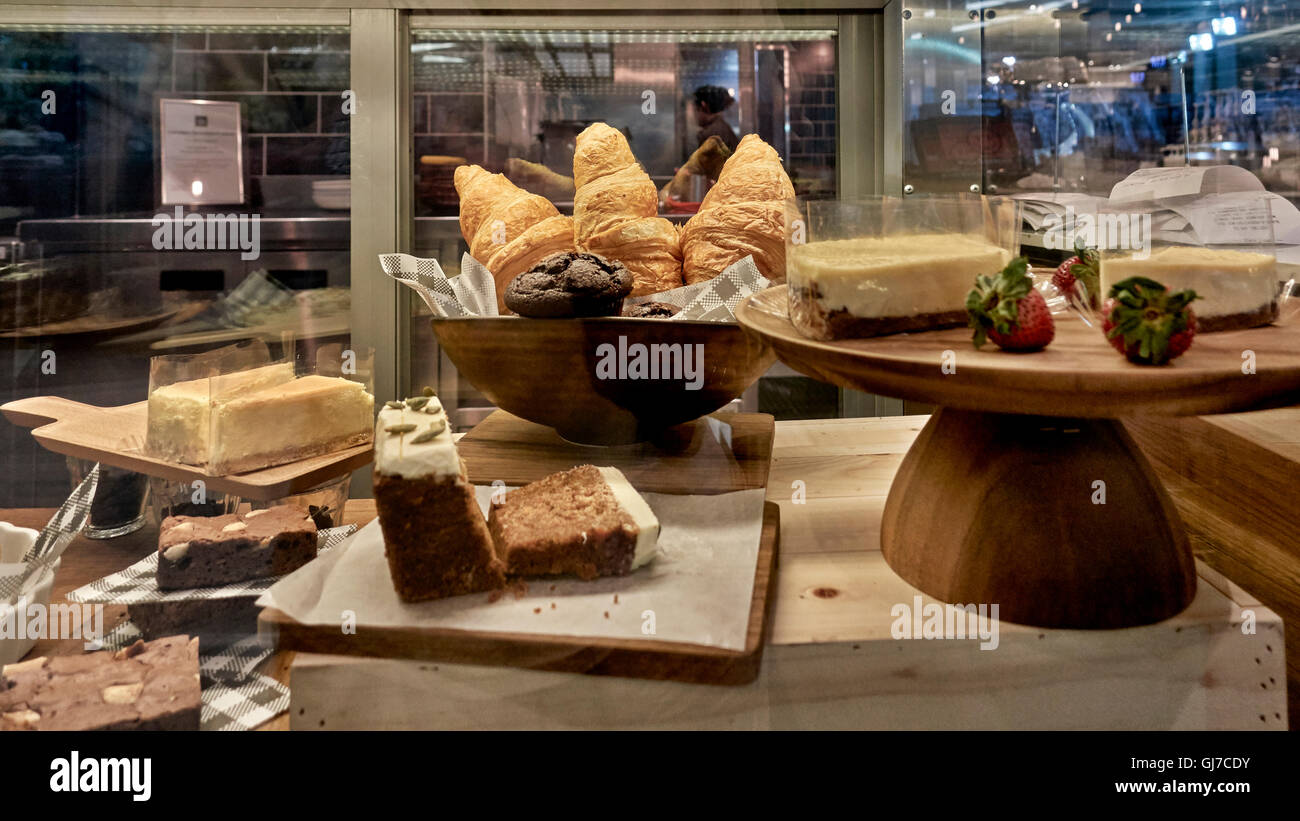 Des gâteaux et des croissants de fantaisie derrière un écran de verre cabinet. Banque D'Images
