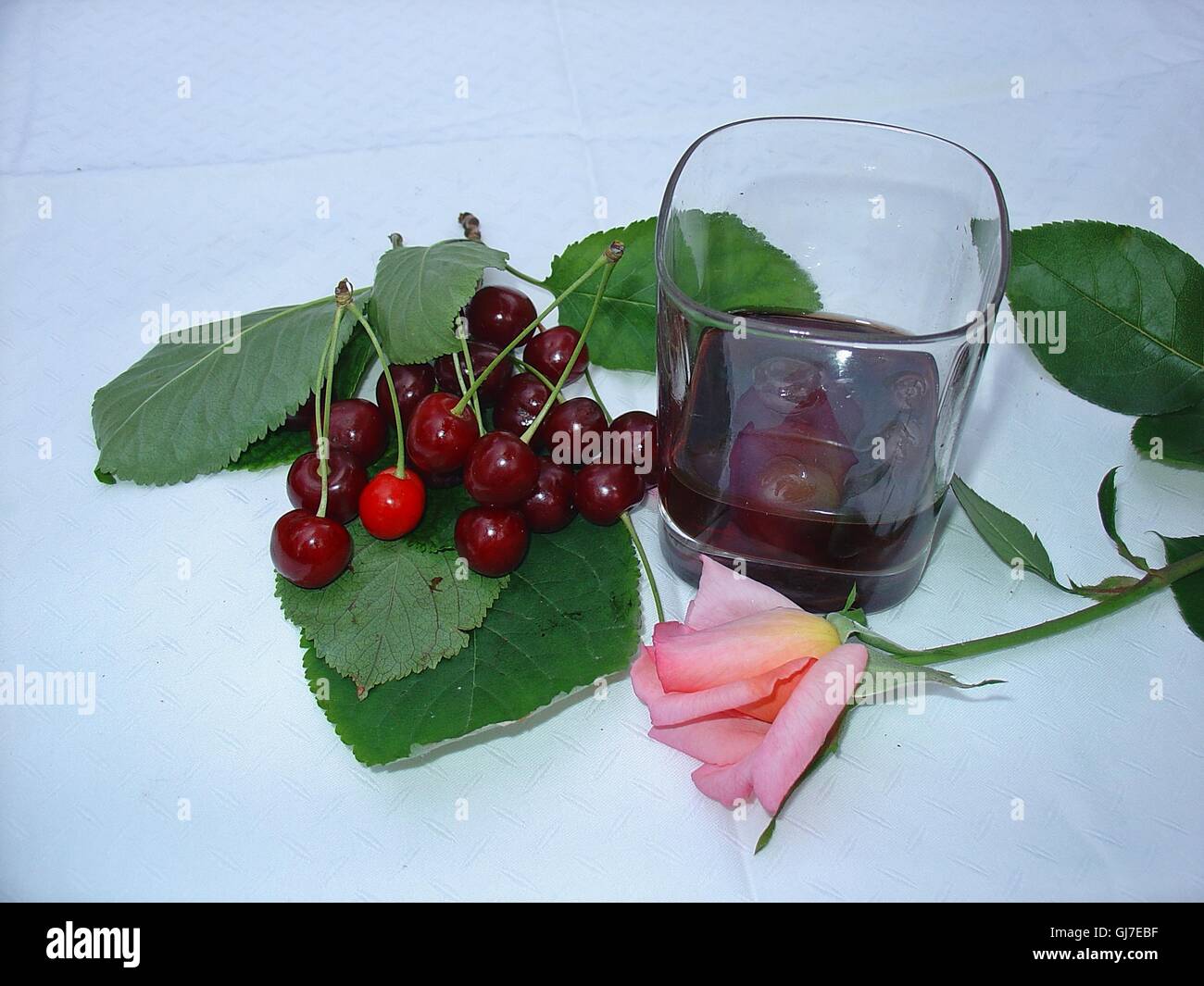 Cerises fraîches et liqueur de cerise...et rose rose... Banque D'Images