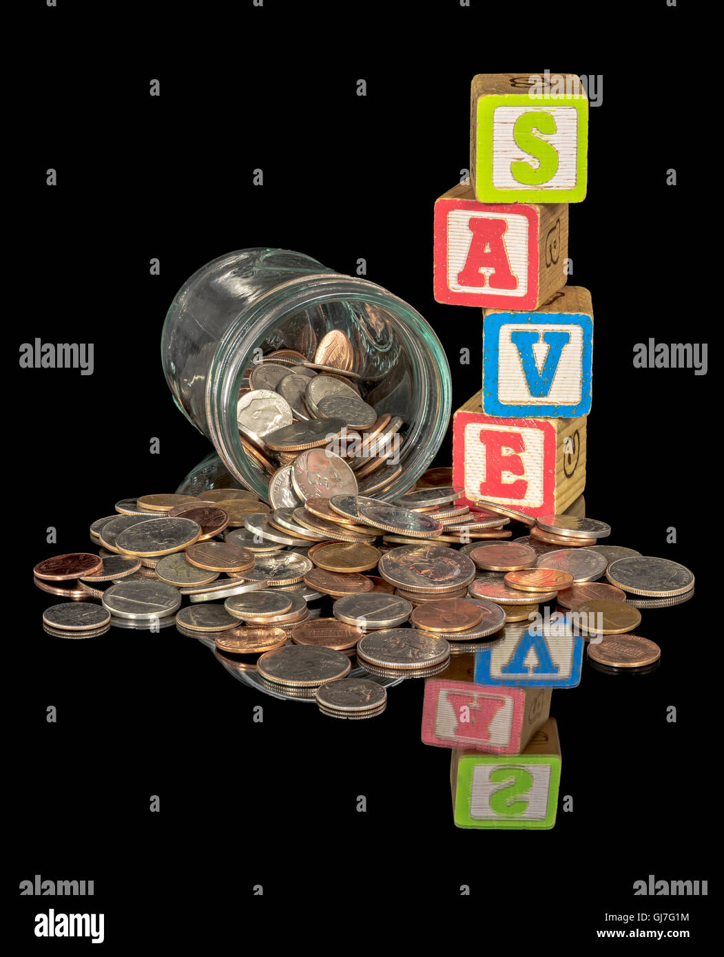 Pièces de monnaie dans un pot coulé sur une table avec le mot en blocs sauvegarder Banque D'Images
