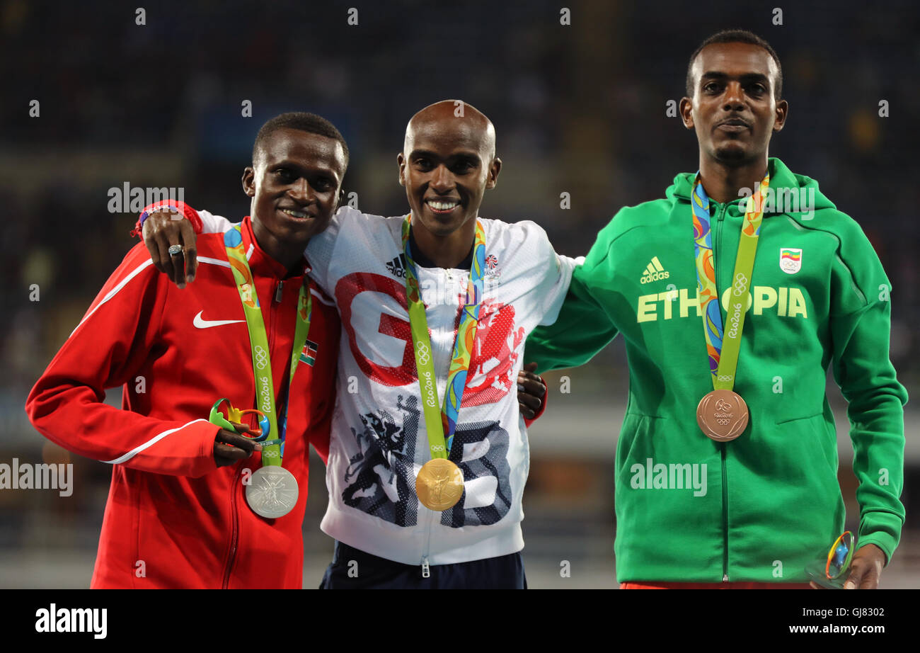 La société britannique Mo Farah (centre avec sa médaille d'or après la finale 10 000m hommes avec de l'argent et bronze Paul Kipngetich Tanui du Kenya (à gauche) et de l'Éthiopie Tamirat Tola (droite) aux Jeux Olympiques Stadium sur le huitième jour de la Jeux Olympiques de Rio, au Brésil. Banque D'Images