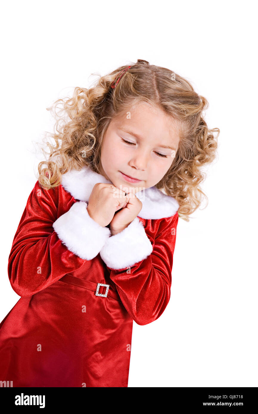 Petite fille en robe de velours rouge, célèbre Noël isolé sur blanc. Banque D'Images