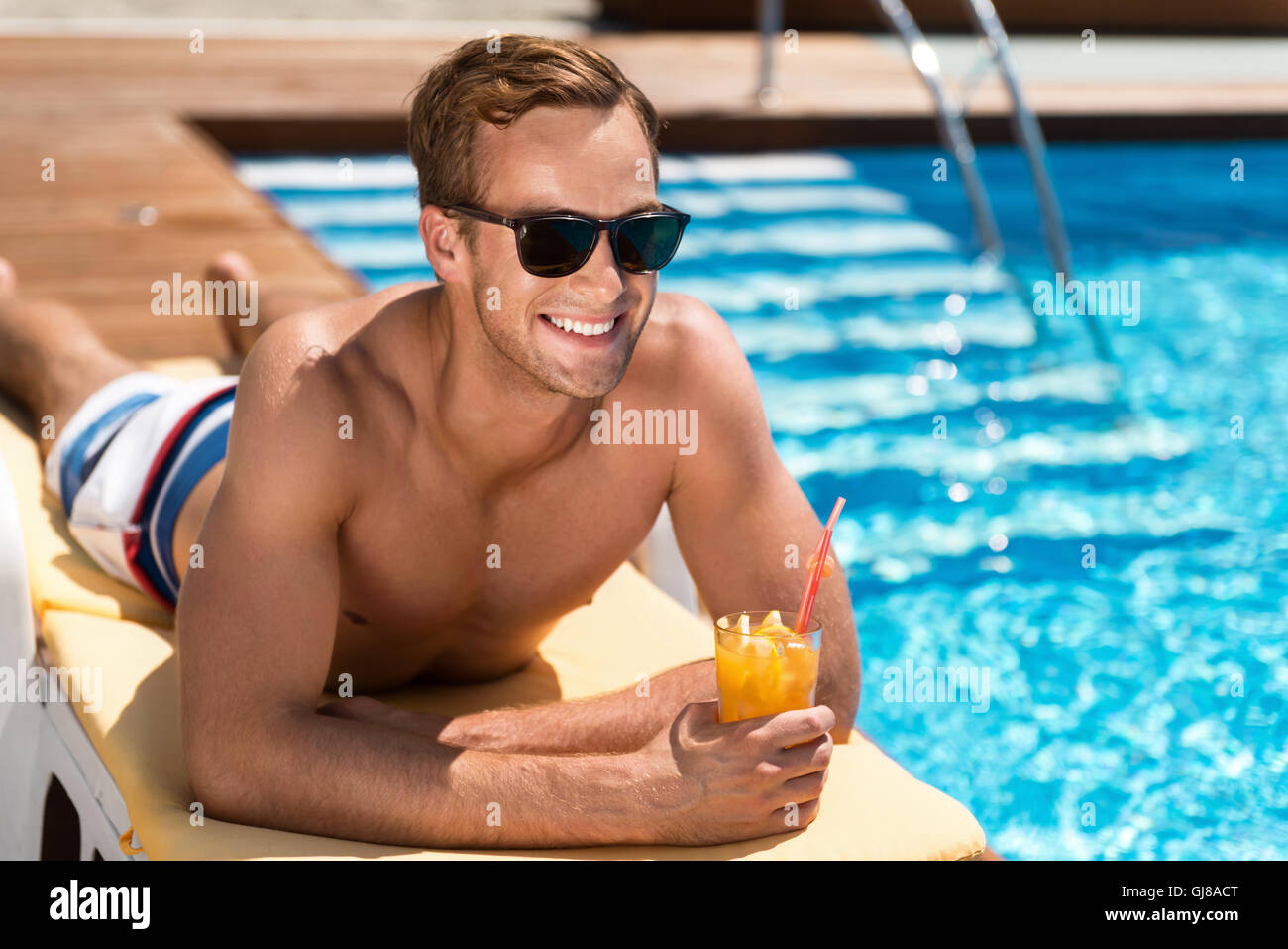 Bel homme positif allongé sur le transat Banque D'Images