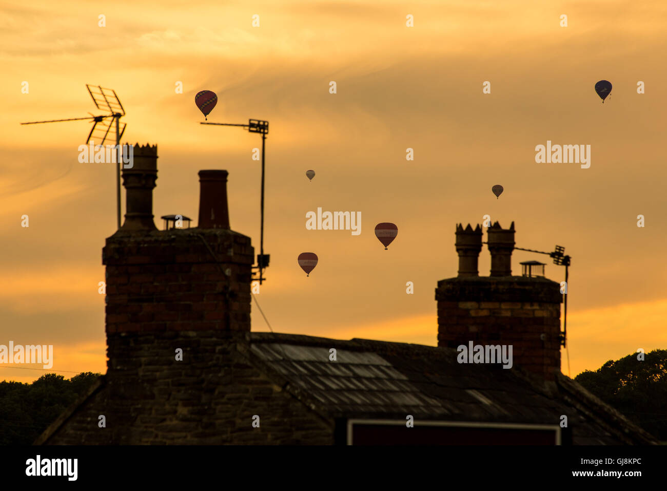 Bristol, Royaume-Uni. 13e Août 2016. L'ascension de la Bristol Balloon Fiesta Festival arrive enfin en cours après des retards en raison des vents violents depuis le jeudi. Un magnifique coucher de soleil a agi comme une toile de fond à plusieurs ballons qui a pris au ciel après les organisateurs du festival ont donné le feu vert pour décoller. Les ballons dérivaient sur la ville de Bristol vers les hameaux de Bitton et Keynsham avant de toucher par champs aléatoires et de parc de nombreux kilomètres de l'Ashton Court site du festival. Credit : Wayne Farrell/Alamy Live News Banque D'Images