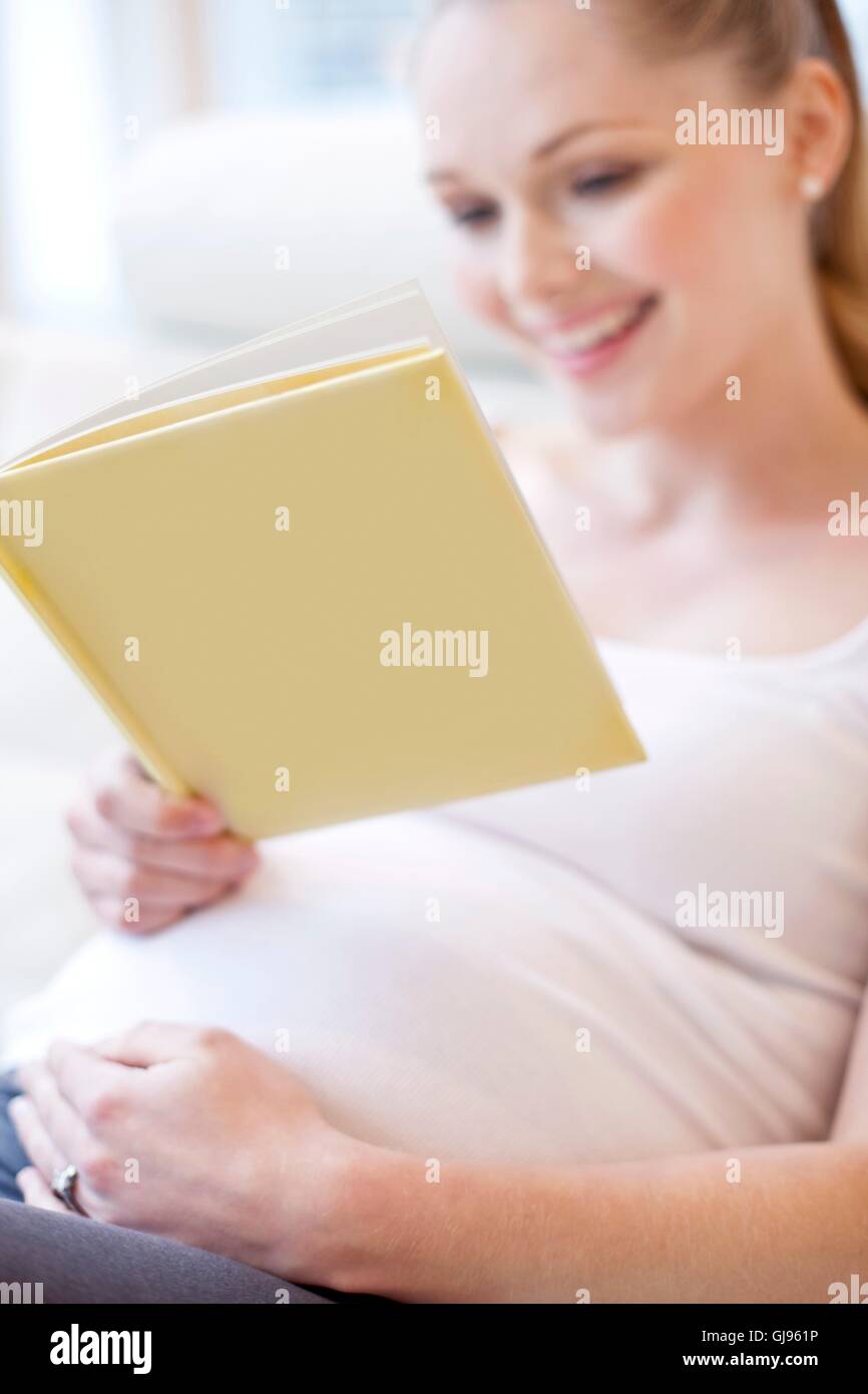 Parution du modèle. Pregnant woman reading book. Banque D'Images