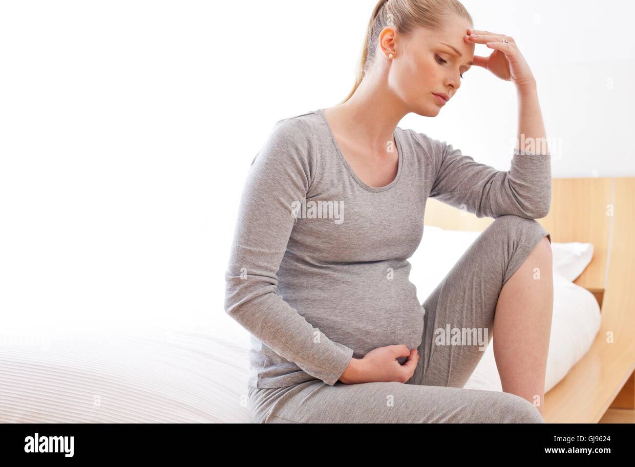 Parution du modèle. Femme enceinte avec la main sur le ventre de toucher la tête. Banque D'Images