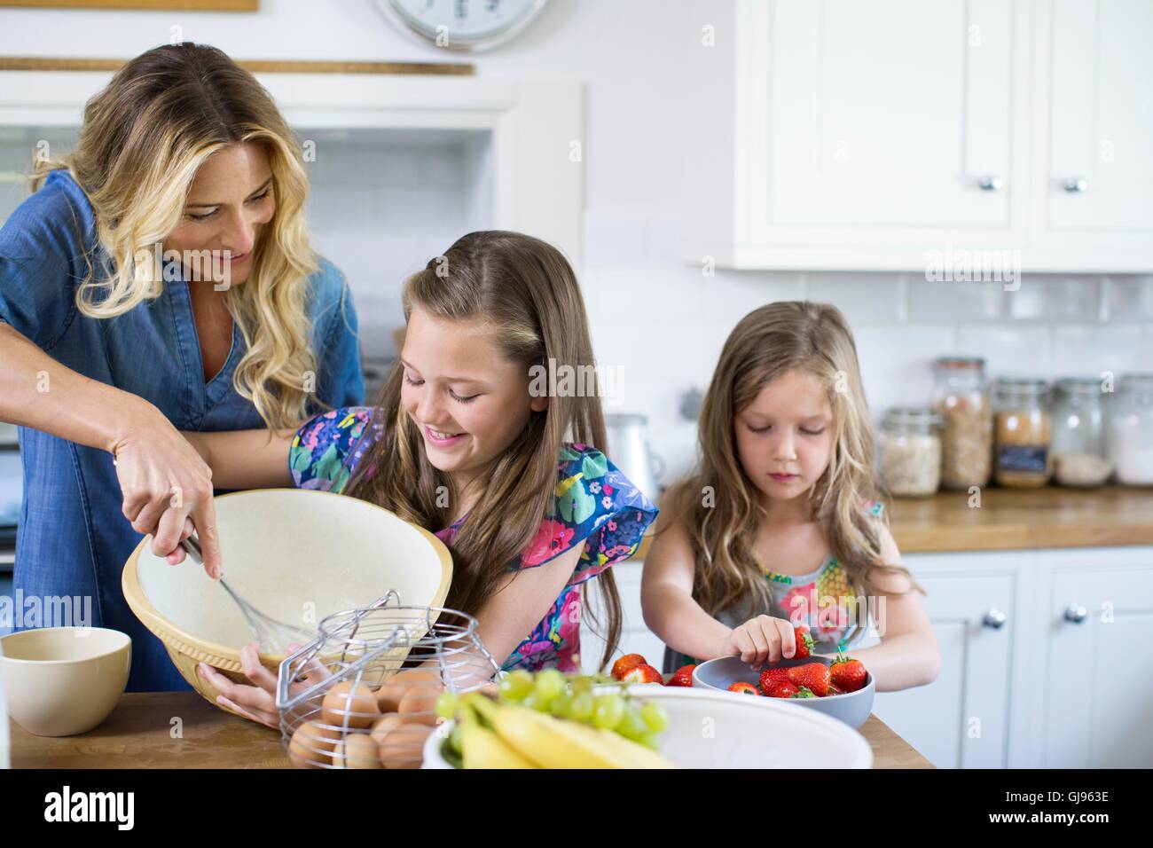 Parution de la propriété. Parution du modèle. La mère et les deux filles la cuisson dans la cuisine. Banque D'Images