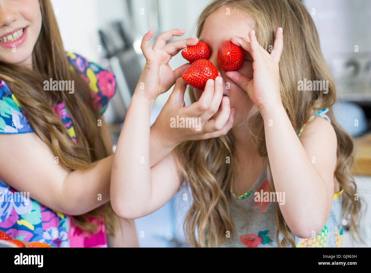 Parution de la propriété. Parution du modèle. Jeune fille avec des fraises couvrant ses yeux. Banque D'Images