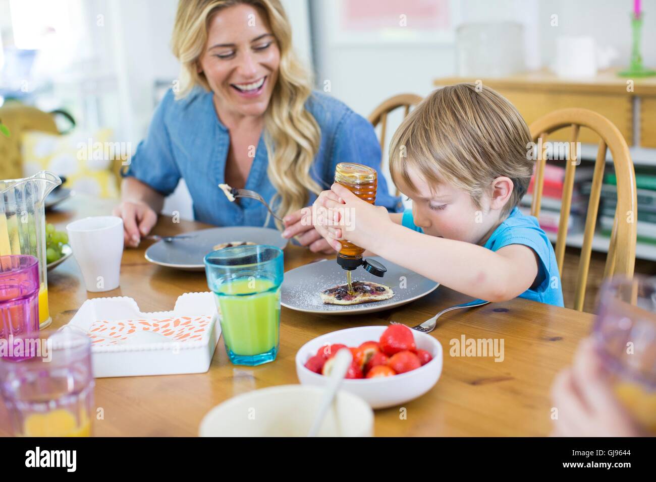Parution de la propriété. Parution du modèle. Enfant de manger à table à manger des crêpes avec Maman. Banque D'Images