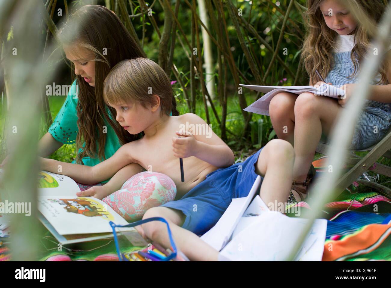 Parution de la propriété. Parution du modèle. Enfants jouant dans un repaire dans le jardin. Banque D'Images