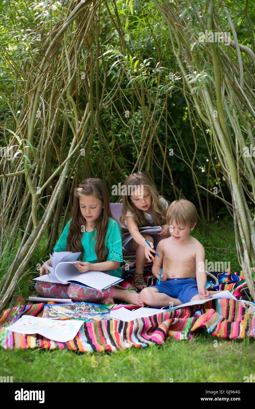 Parution de la propriété. Parution du modèle. Enfants jouant dans un repaire dans le jardin. Banque D'Images