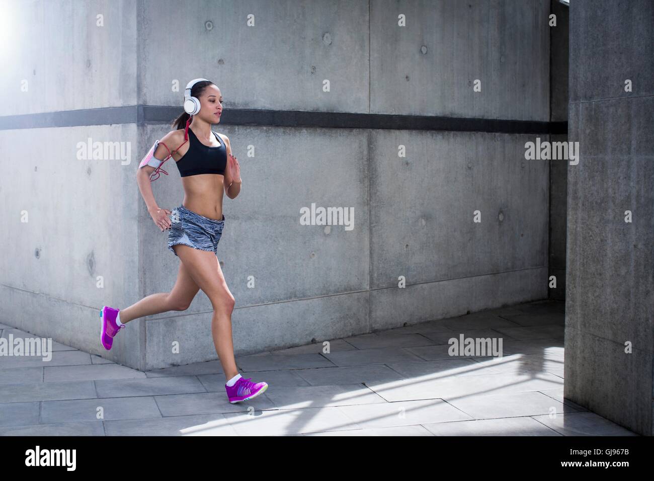 Parution du modèle. Jeune femme portant des écouteurs d'exécution. Banque D'Images