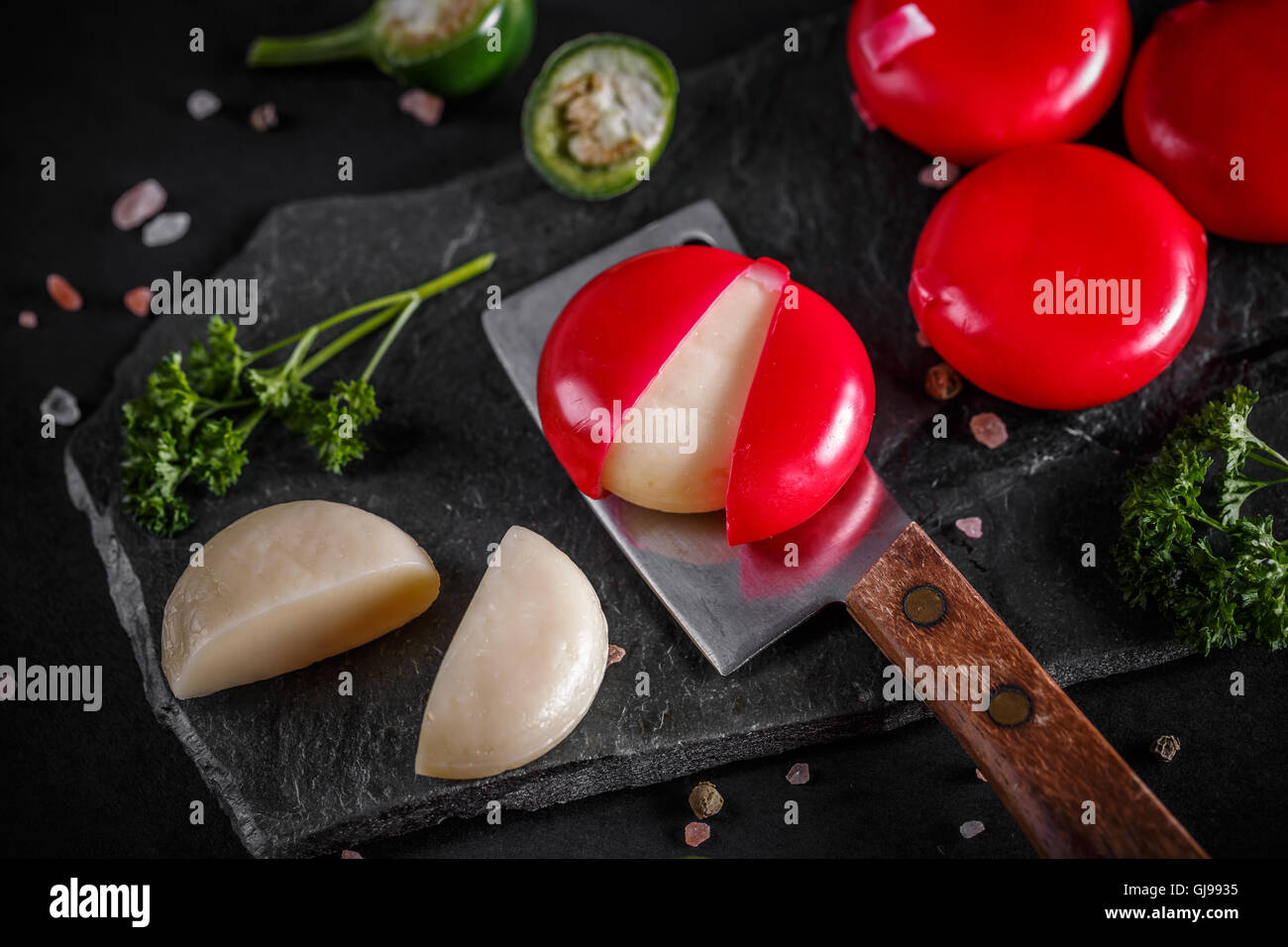 Babybel fromage en cire rouge sur fond noir Banque D'Images