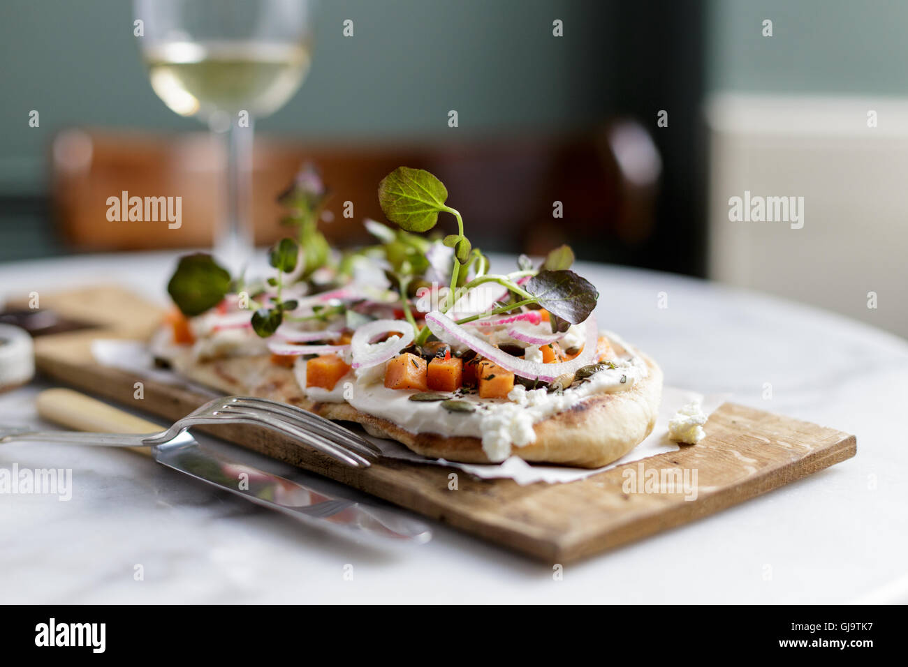 Un pain plat ou salade de fromage de chèvre et pizzetta avec radis, l'oignon rouge, squash et feuilles de bébé Banque D'Images