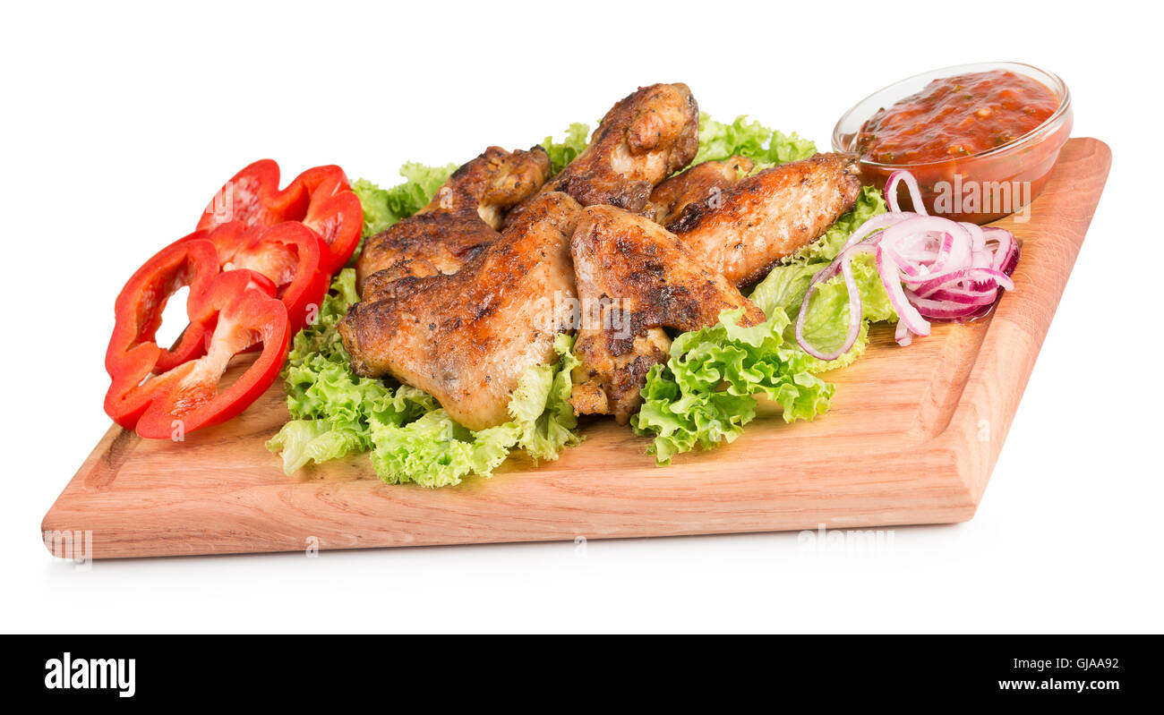 Ailes de poulet avec la sauce et des légumes sur la table en bois. Banque D'Images