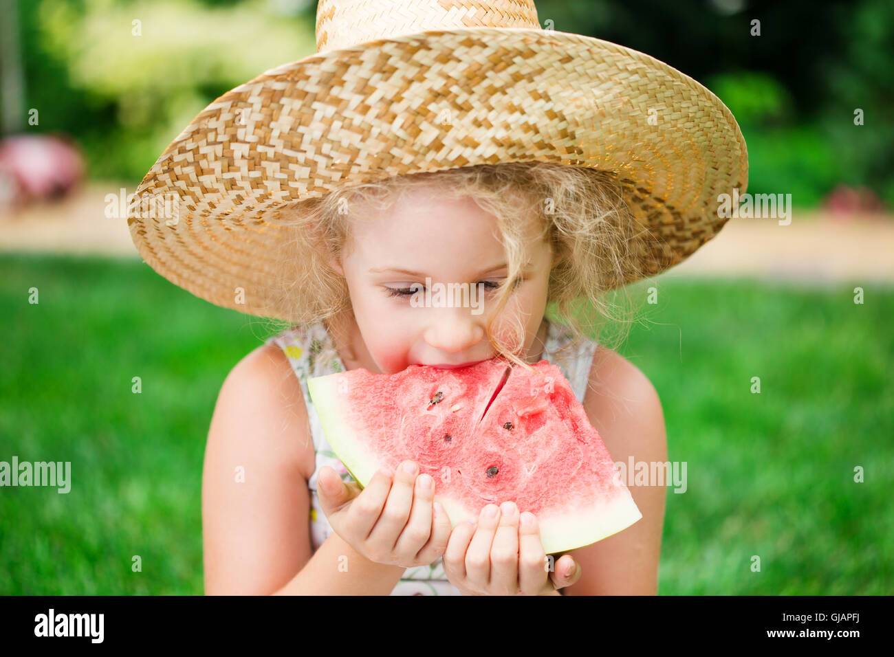 Jolie petite blonde girl eating watermelon, piscine d'été Banque D'Images