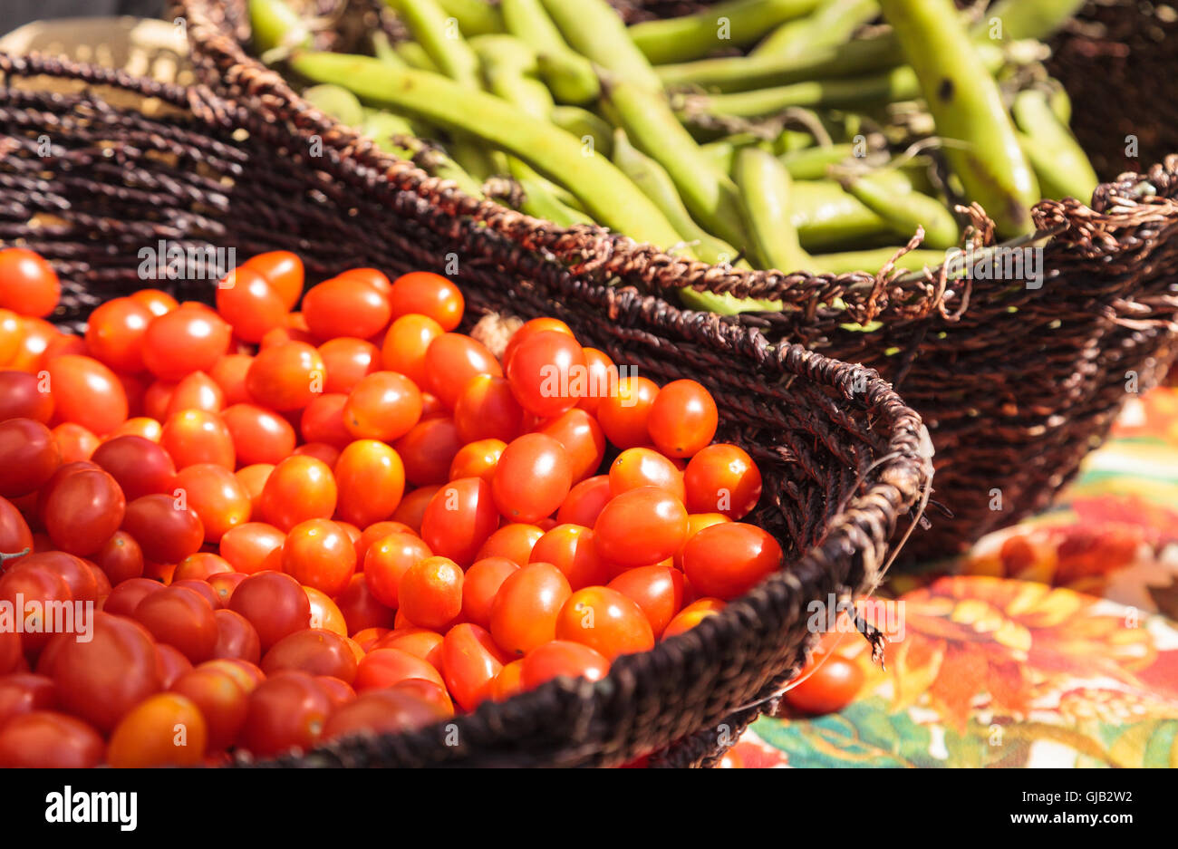 Mélange de tomates cerises colorées et les haricots cultivés et récoltés dans le sud de la Californie et affichée à un marché de producteurs. Banque D'Images