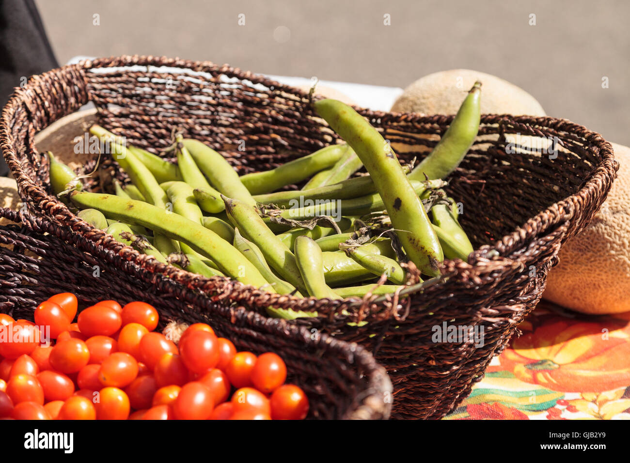 Mélange de tomates cerises colorées et les haricots cultivés et récoltés dans le sud de la Californie et affichée à un marché de producteurs. Banque D'Images