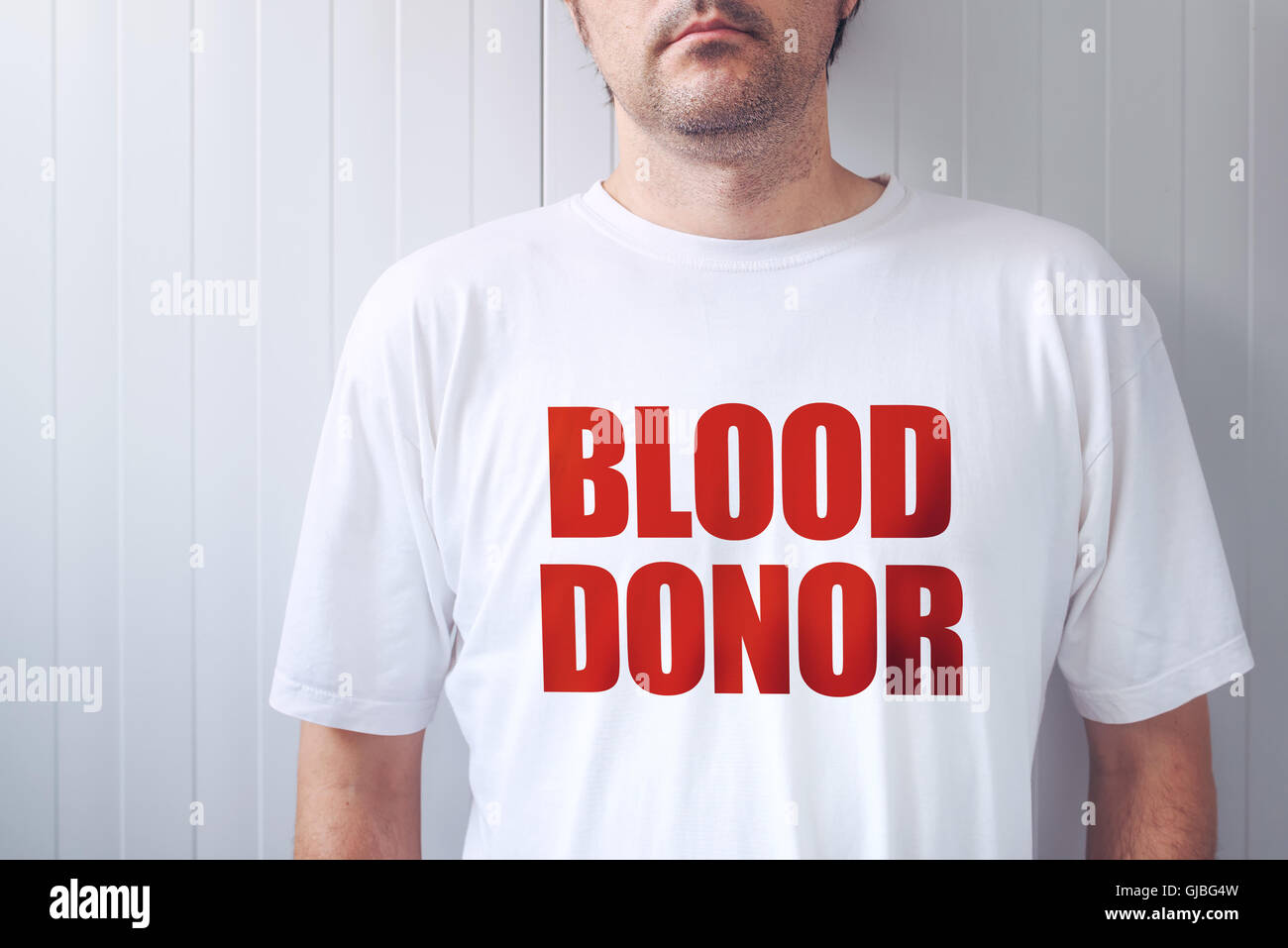 Don de sang portant des T-shirt blanc, personne mâle posing at camera Banque D'Images