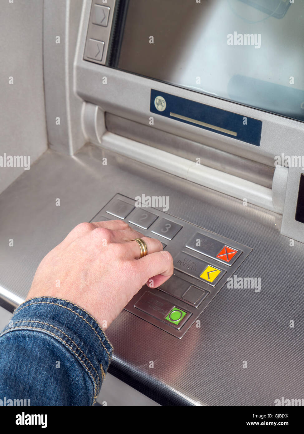 La main de femme libre de saisie de code PIN sur le clavier de la machine ATM Banque D'Images