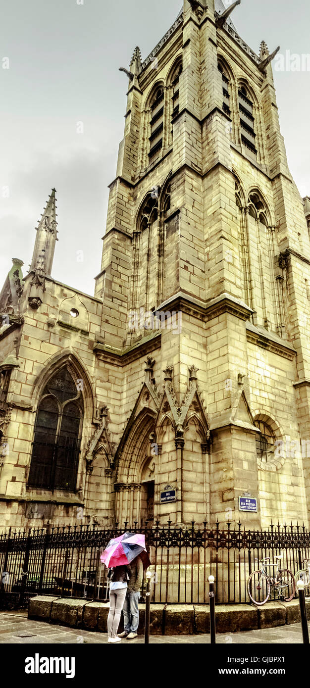 Couple sous la pluie à côté d'une cathédrale à Paris Banque D'Images