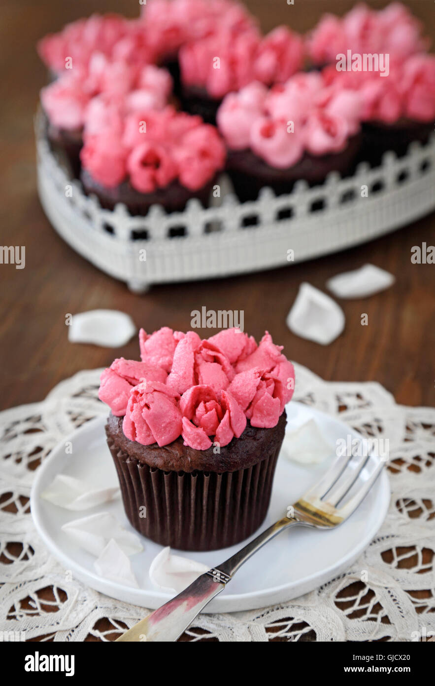 Cupcakes. Petits gâteaux au chocolat avec crème au beurre vanille rose rose Banque D'Images