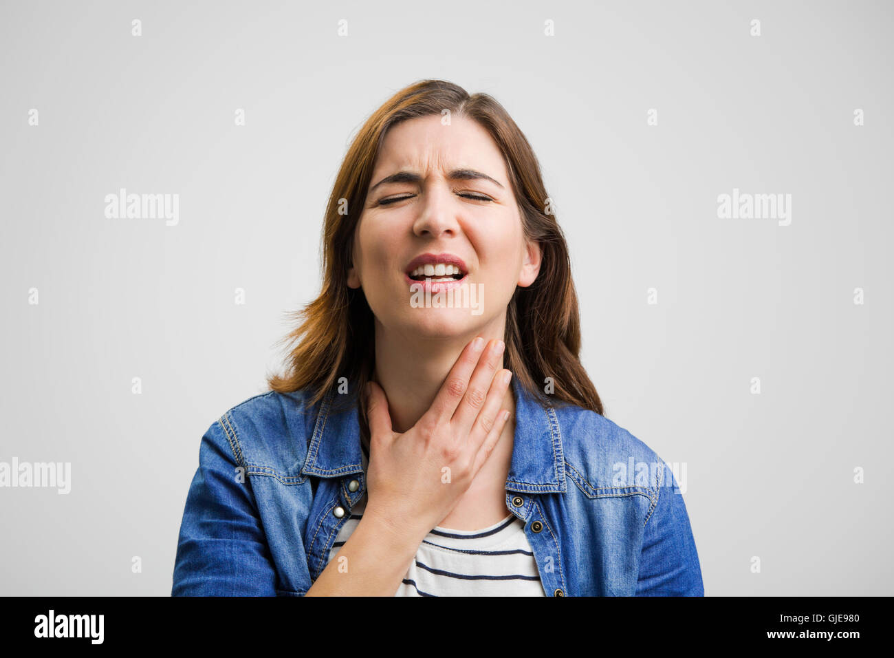 Femme frustrée dans la douleur avec un mal de gorge Banque D'Images