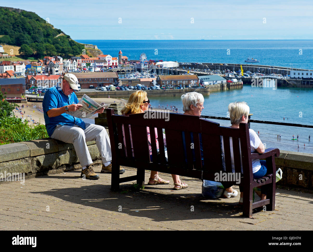 Visiteurs détente sur banc, contempler sur le port, Scarborough, North Yorkshire, England, UK Banque D'Images