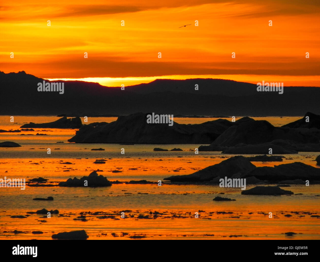 Ciel orange vif au coucher du soleil de l'Arctique du groenland icebergs avec piscine Banque D'Images