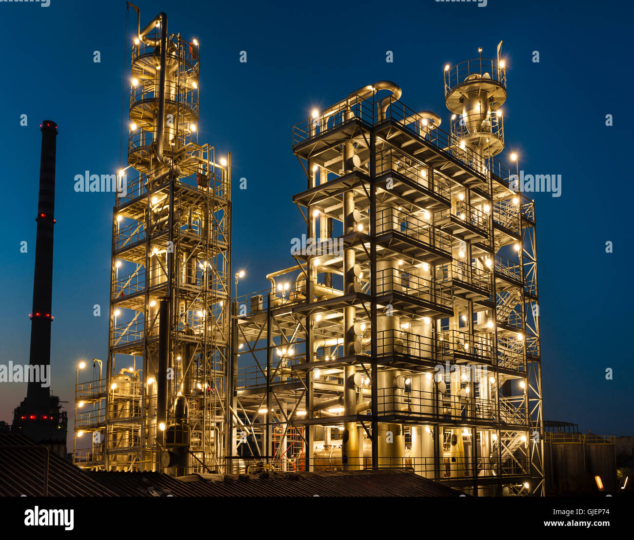 Vue générale d'une raffinerie de pétrole est éclairée la nuit, les pipelines et les tours, l'industrie lourde Banque D'Images