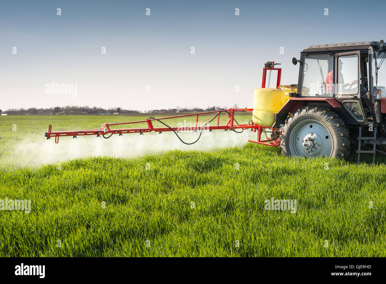 La pulvérisation du tracteur champ de blé avec pulvérisateur Photo Stock -  Alamy