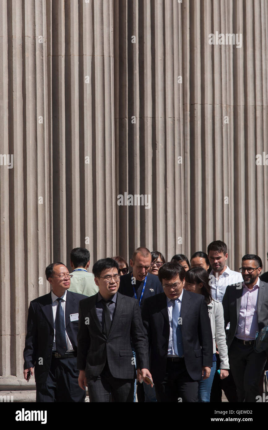 Les hommes d'affaires chinois en visite à pied sous les piliers de la Banque d'Angleterre à Threadneedle Street, City of London, UK. Banque D'Images