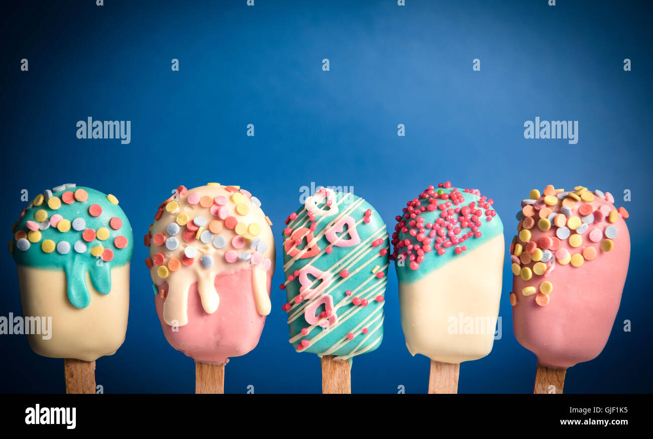Cake pops dans la crème glacée forme sur fond bleu Banque D'Images