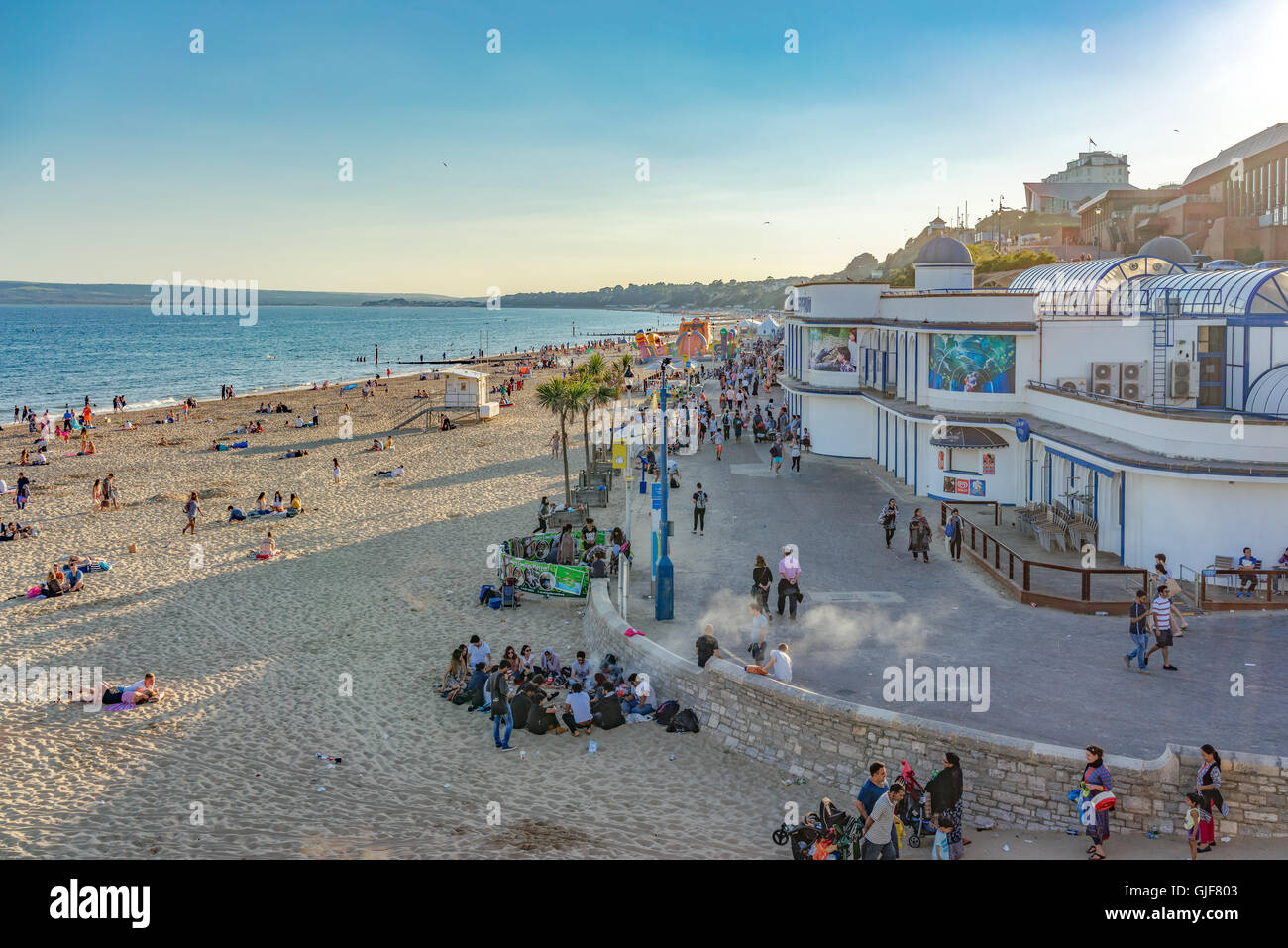 Excursionnistes et les vacanciers profiter du temps chaud et les eaux claires de la plage de Bournemouth sur la côte sud du Royaume-Uni. Banque D'Images
