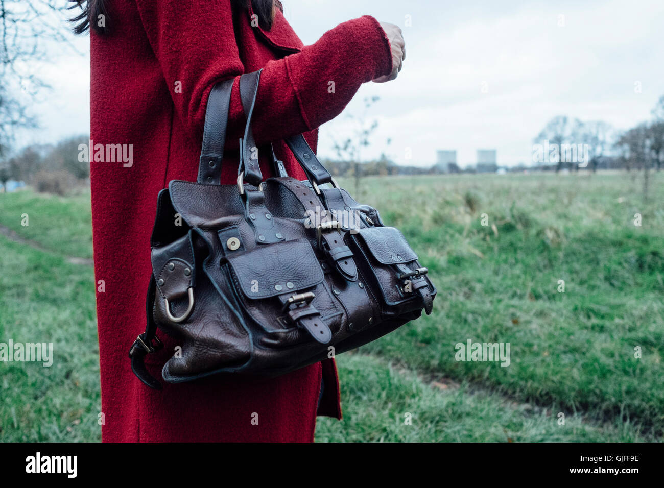 Femme en manteau rouge tenant un sac à main en cuir Mulberry Roxanne Photo  Stock - Alamy