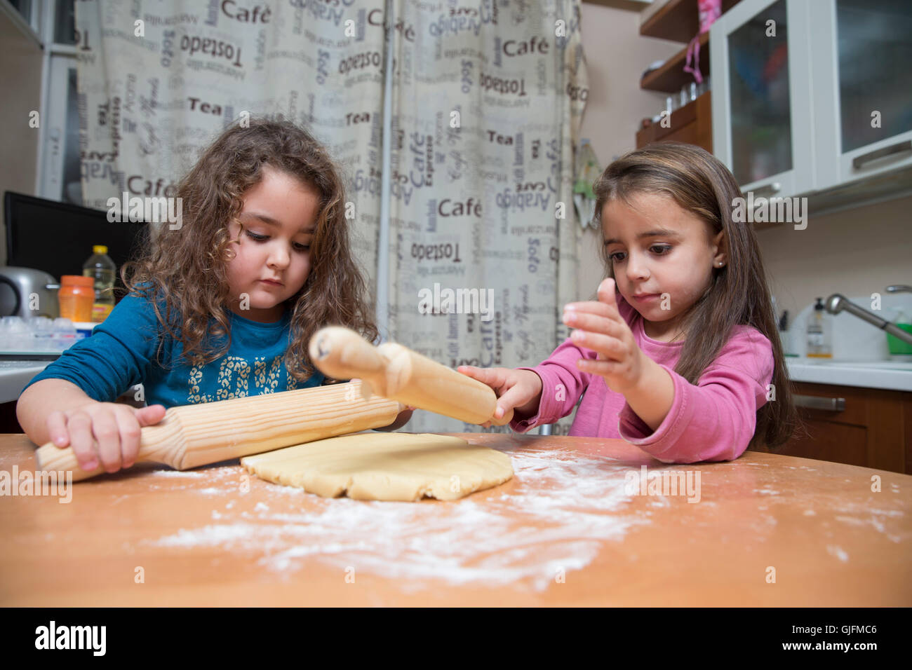 Deux beaux enfants dans la cuisine pâte avec des rouleaux à pâte en cuisine Banque D'Images
