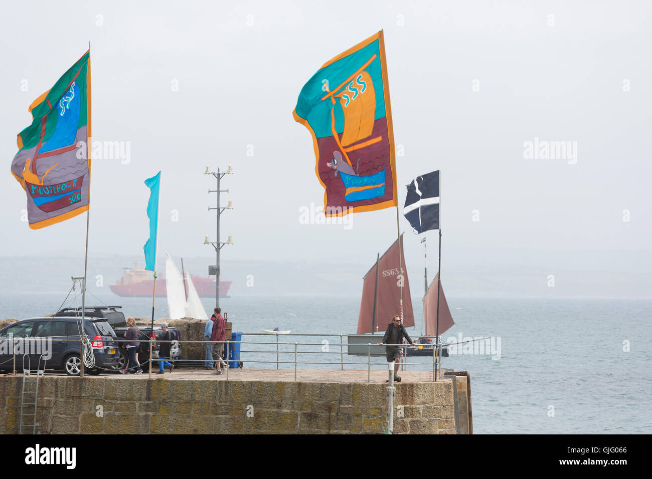 Les sels de mer et de voiles, des drapeaux colorés dans le vent, port Mousehole, Cornwall, UK. Banque D'Images