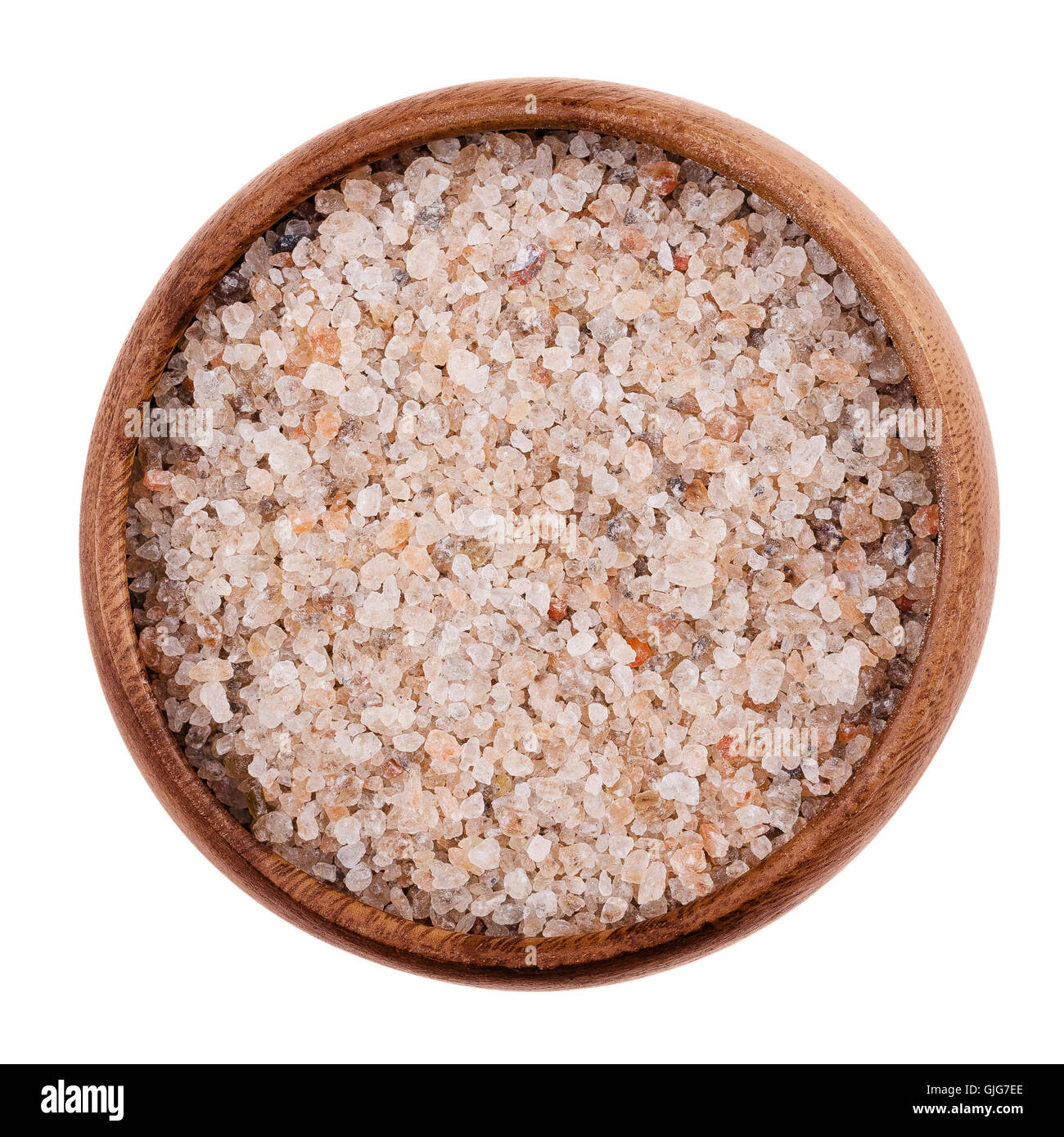 Red Rock naturel le sel dans un bol sur fond blanc. Les grains comestibles et de chlorure de sodium, NaCl, également l'halite. Banque D'Images