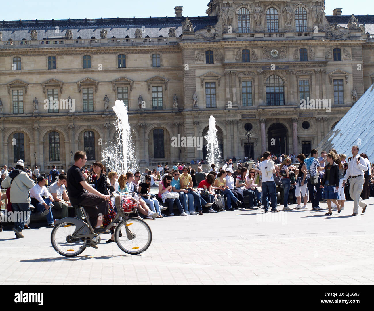 Les foules au Louvre Museum & Art Gallery, Paris, France, avec man riding bicycle communal Banque D'Images
