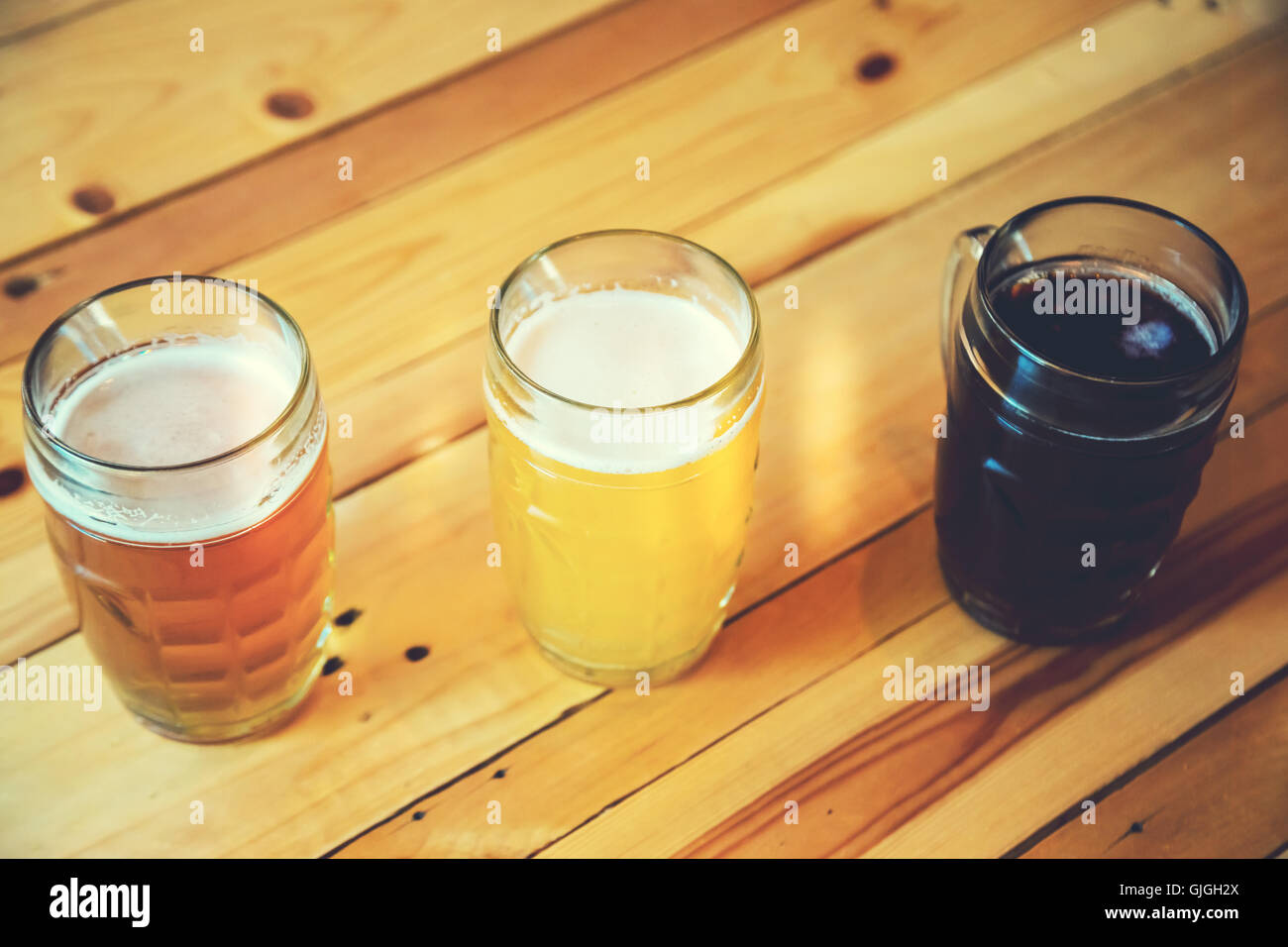 Magnifique cadre de l'Oktoberfest. verres de blanc frais à froid, la lumière et l'obscurité de la bière sur le comptoir du bar en bois dans le pub. Banque D'Images