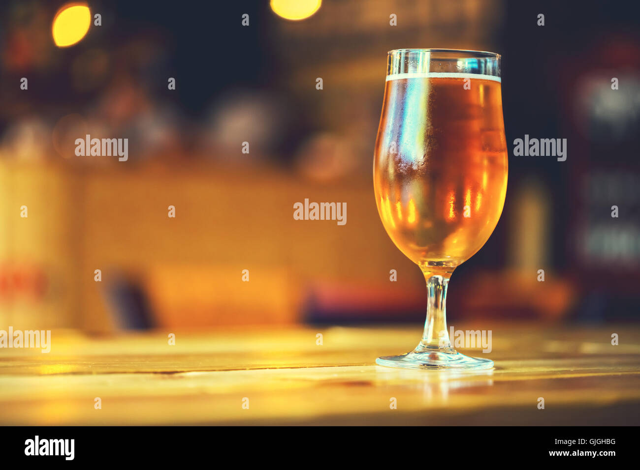 Magnifique cadre de l'Oktoberfest. verre de bière blonde fraîche froide sur un comptoir de bar en bois dans un pub avec de l'espace libre pour votre Banque D'Images