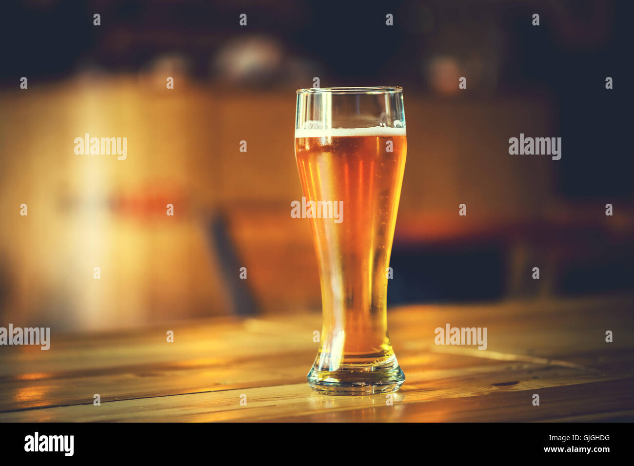 Magnifique cadre de l'Oktoberfest. verre de bière blonde fraîche froide sur un comptoir de bar en bois dans un pub avec de l'espace libre pour votre Banque D'Images