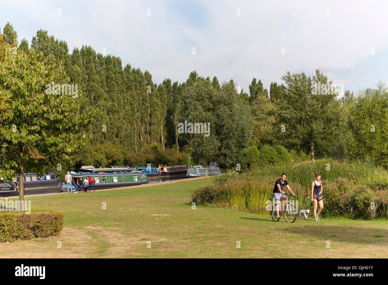 Milton Keynes, Royaume-Uni. 16 août, 2016. Une journée d'été au parc Campbell montrant le bateau moorings sur le Grand Union canal et les gens de côté le magnifique lac bénéficiant d'une belle journée calme. Crédit : Robert Norris/ Alamy Live News Banque D'Images