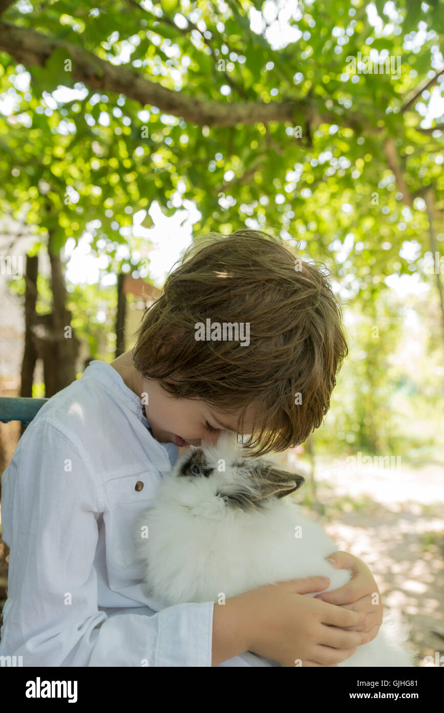Boy holding fluffy lapin pet Banque D'Images