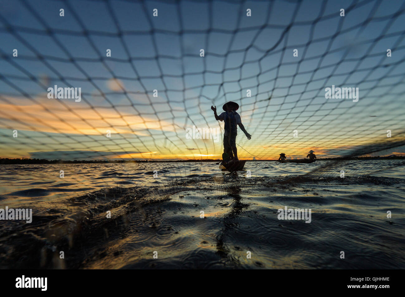 Fisherman casting filet de pêche au coucher du soleil, Nong-khai (Thaïlande), Banque D'Images
