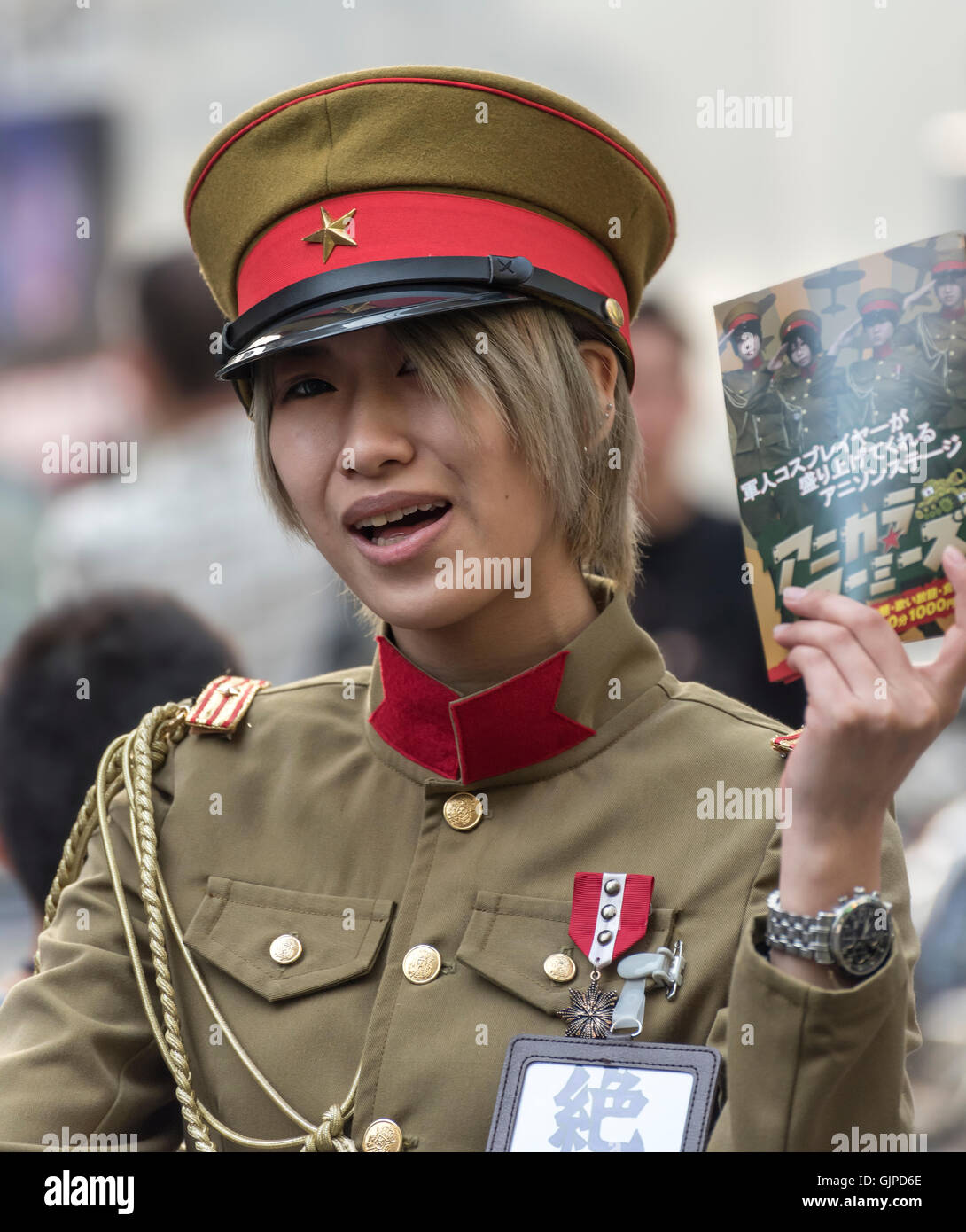 Jeune femme en uniforme de l'Armée impériale japonaise distribuant des feuillets dans Akihibara, Tokyo, Japon Banque D'Images